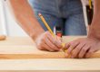 Man measuring timber and marking a line