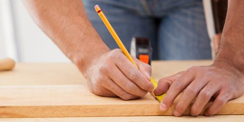Man measuring timber and marking a line