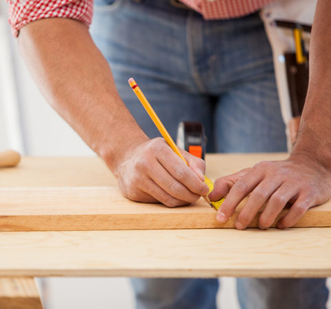 Man measuring timber and marking a line